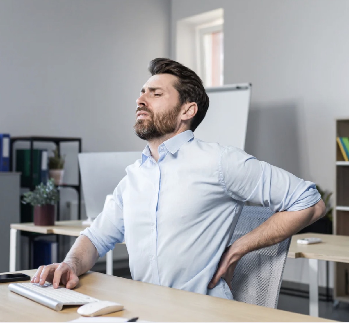 Office worker with lower back pain showing common slip disc symptoms in Jaipur